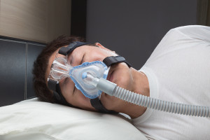 un homme qui dort avec un appareil d'apnée du sommeil