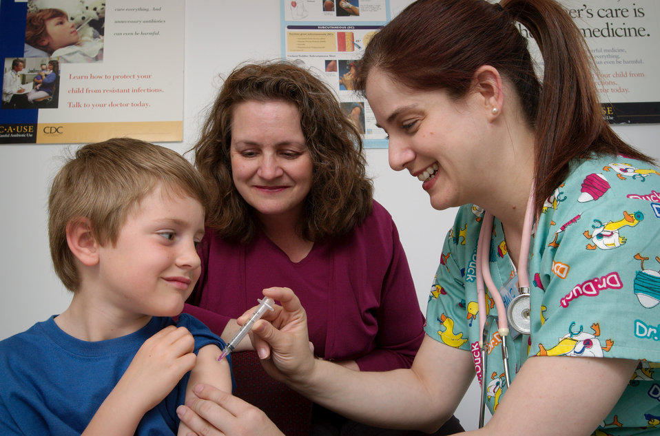 un garçon qui se fait vacciner par une infirmière