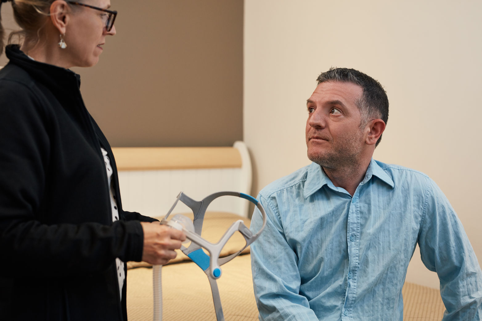 un homme qui écoute attentivement une professionnelle de la santé