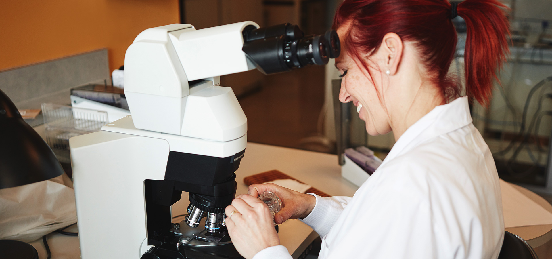 laboratory technician looking through a micoscope