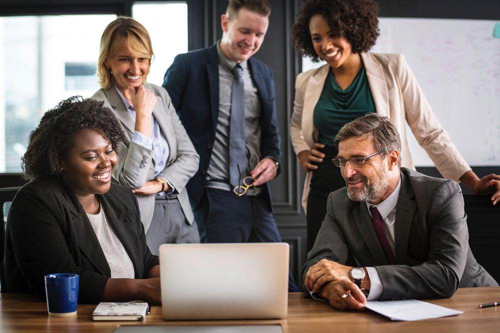 professionnels discutant autour d'un ordinateur portable